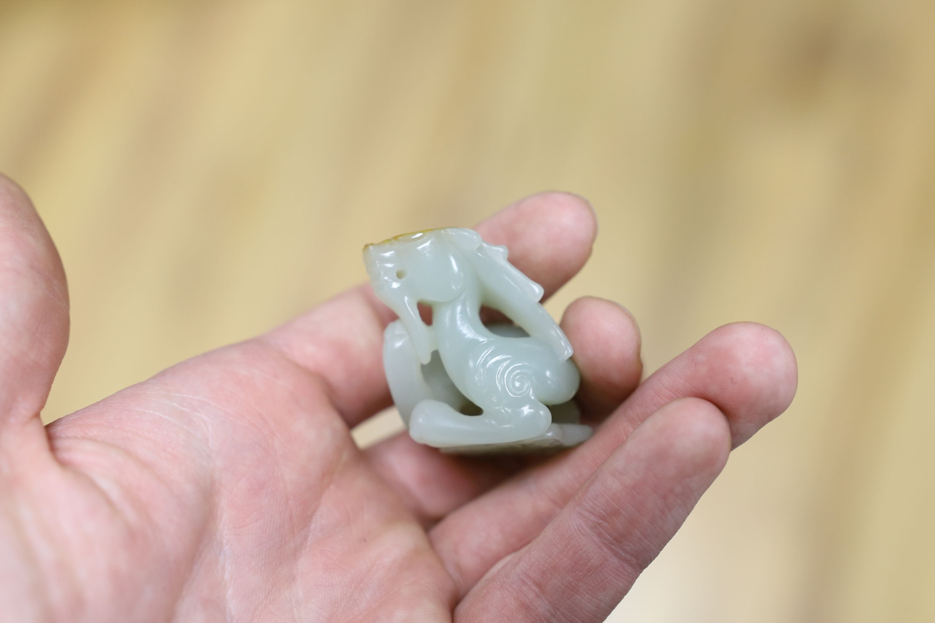 A Chinese pale celadon and russet skin jade figure of a dragon, 4cm high